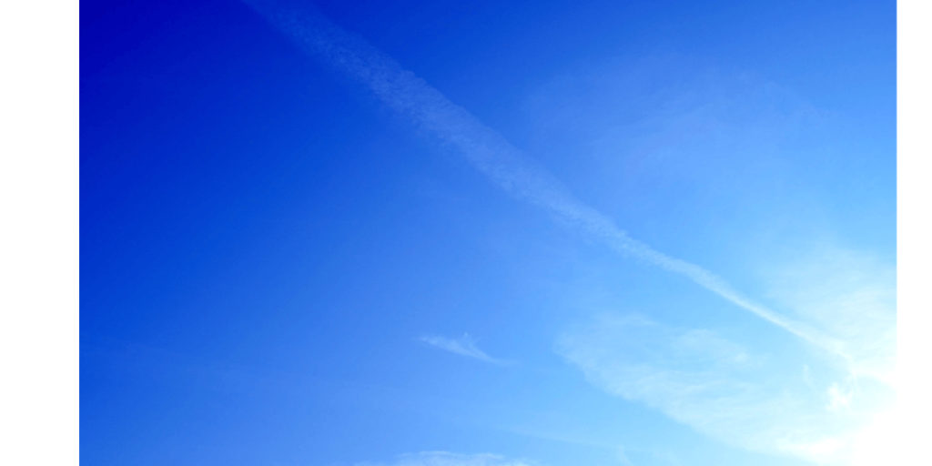 青空の真ん中を走る１本の飛行機雲