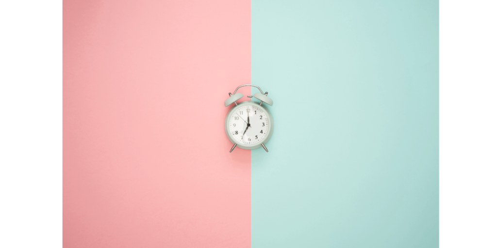 ピンクと青の背景の上の置時計